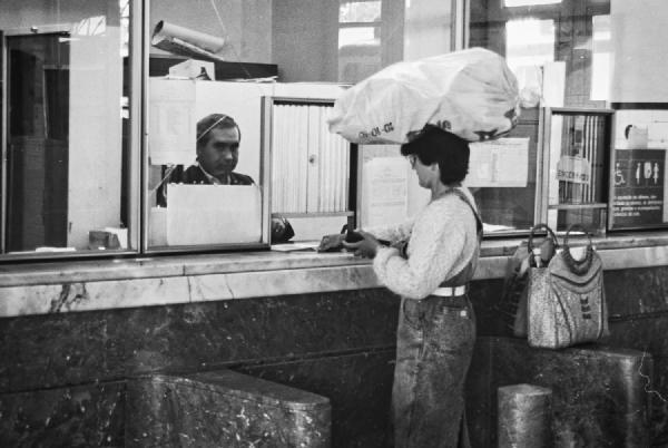 A woman buys a train ticket at the old station of Viseu. In many Portuguese villages, it was common to see women carrying heavy bags or baskets perfectly balanced on their heads, a sight that always fascinated me. Here, there’s a quiet contrast: a traditional gesture set against the more formal setting of a city station.