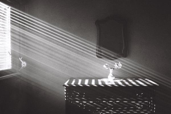 Light cuts through the room in perfect diagonal lines, turning an ordinary space into something almost abstract. The closed blinds shape the light, guiding the eye over the dresser to the faint reflection in the mirror. The contrast between brightness and shadow defines the composition. This was my old bedroom, often filled with smoke from the fireplace in winter.