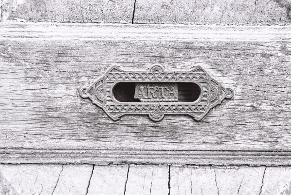 An old mailbox slot once marked “CARTAS”, now missing the “C” and the “S,” leaving only “ARTA”. Time has softened every edge, turning decay into texture. There’s a quiet beauty in the details — the craft, the aging surface, the sense that countless letters once passed through this small opening.